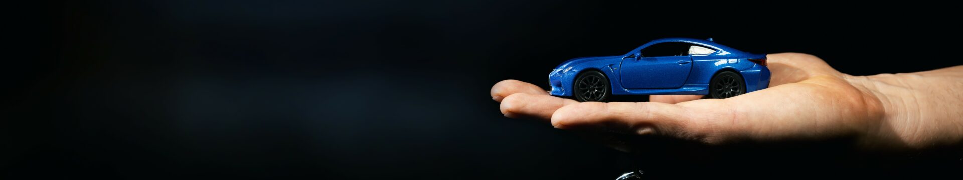 Main tendue offrant une petite voiture pour enfant